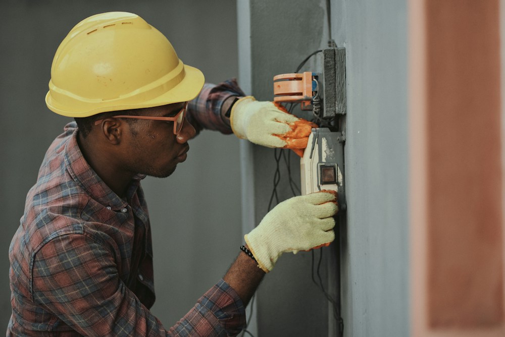 Professional wearing protective equipment installing electrical wiring in Nigeria